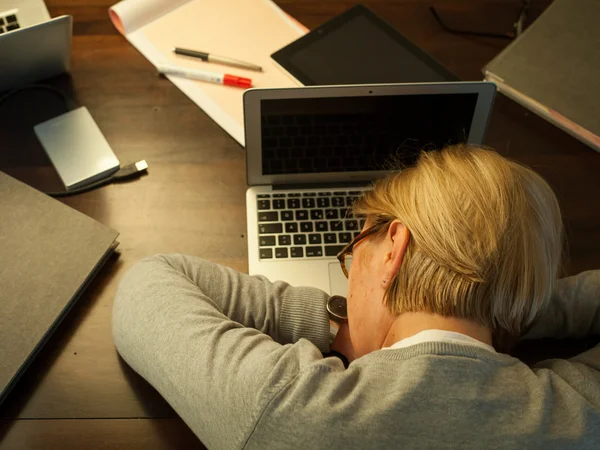 Total übermüdet Frau schläft auf Laptop ein
